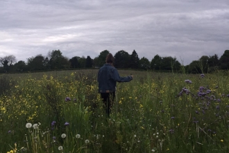Nature blogger Jennifer Lane walking through a wildflower meadow
