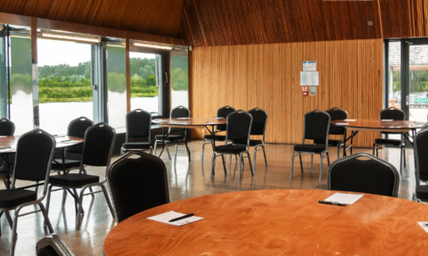 A view of our Meadow Lake Suite set up with tables and chairs for a business conference.