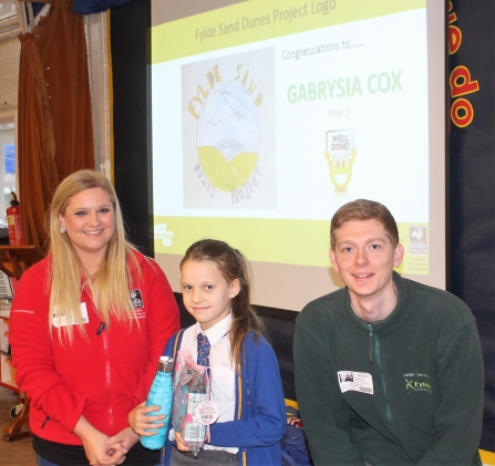 Amy Pennington and Andy Mills awarding Gabrysia with her prizes for her sand dunes logo