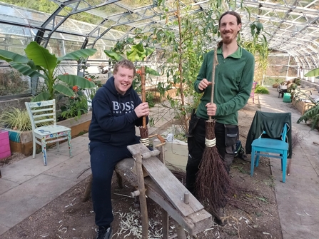 Participants and staff take part in a besom broom making workshop, hosted at the greenhouses