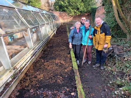 Volunteers by a new bed at the greenhouse project