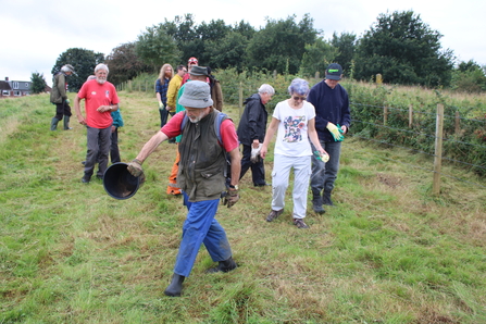 Volunteers sowing yellow rattle seed at Cutacre in August 2023.