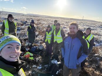 A group of people on a sunny, frost covered hill