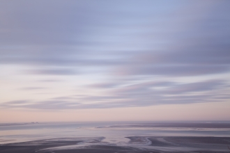 The mudflats of Morecambe Bay on a hazy winter morning at sunrise