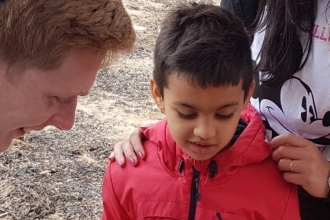 Living Seas North West team talking to a little boy at Seashore Detectives event