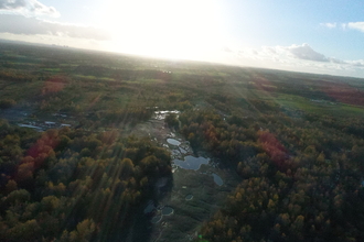 Drone view of Wigan Flashes nature reserve with sun flare
