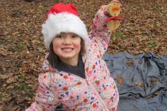 Child smiling with their tree cookie snowman