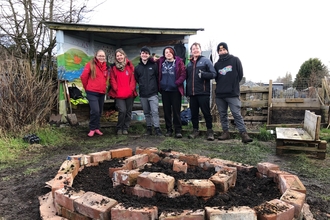 Nature and Wellbeing participants standing by their herb spiral