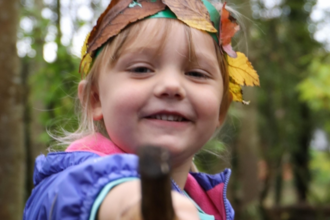 Girls with a leaf crown and pointing with a stick