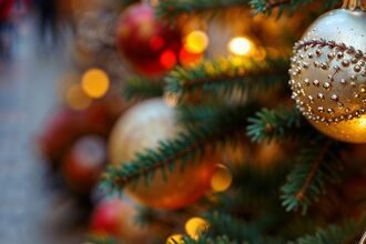 Close up image of Christmas tree with people walking in background.