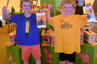 Young boys pose with specialised red squirrel feeders