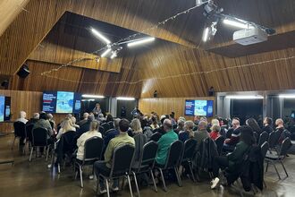 Rows of people sitting down to watch a screening of the People's Emergency Briefing at Brockholes