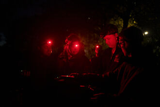 People with red torches for bat walk