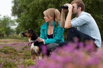 Couple birdwatching with dog
