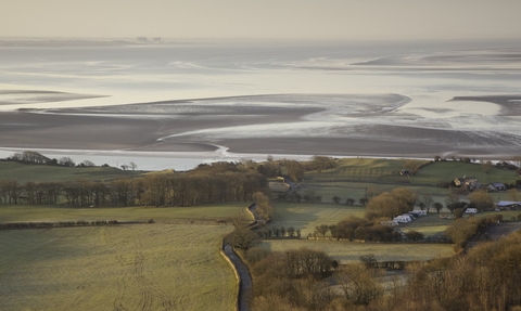 A sweeping view over open fields to Morecambe Bay from Arnside Knott