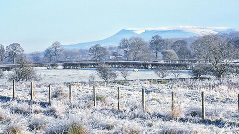 A view across snowy fields to Pendle Hill seen from Brockholes