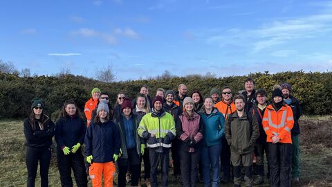 Image of group of volunteers from APEM Limited stood on Freshfield Dune Heath with blue sky