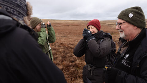 A group of people looking through a lens at moss