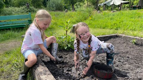 Two children having fun playing in the mud pit at The Hive