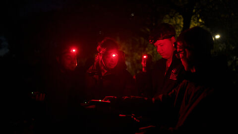 People with red torches for bat walk