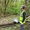 James Hall - Head of Ecological Enterprise - standing in a woodland and wearing a hi-vis jacket.
