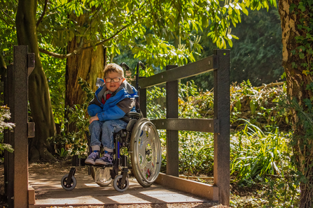 A child in a wheelchair visiting an accessible nature reserve