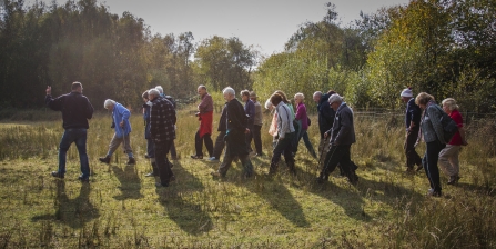 A local group walking at Mere Sands Wood in autumn sunlight