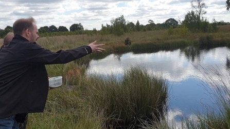 James Grundy MP reintroducing throwing lesser bladderwort into a bog pool at Highfield Moss