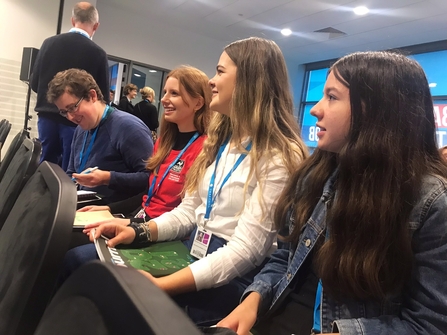 Youth Council members sitting in a seminar at the Conservative Party Conference and smiling