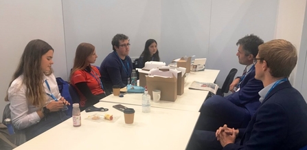 The Lancashire Wildlife Trust Youth Council sitting along a white table opposite The Wildlife Trusts CEO, Craig Bennett