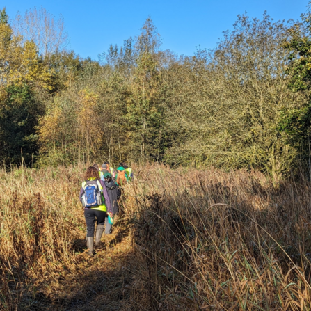 Volunteers heading out into scrubby grassland in the autumn sunshine