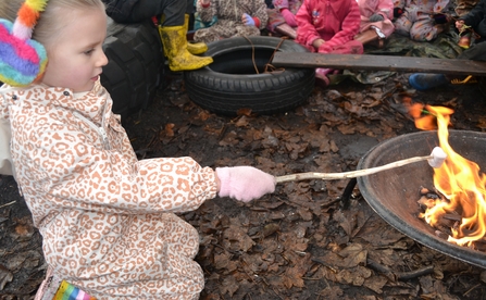 Girl toasting marshmallows on fire
