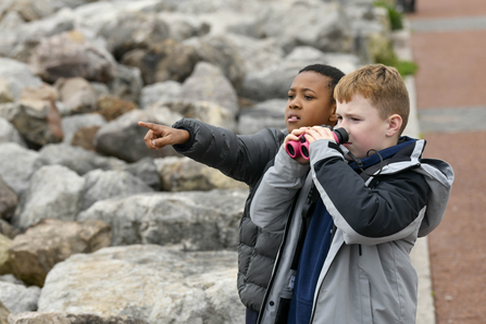 Two young boys looking through binoculars