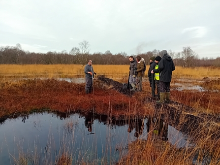Group of people next to a bog pool
