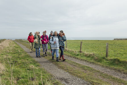 A group of women walking along a costal footpath
