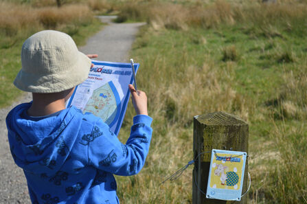 A young boy holding an Xplorer map