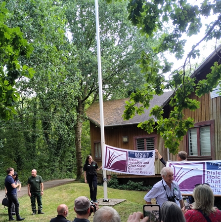 A flag being raised by a wooden building in a woodland