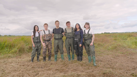 6 people wearing waders standing in a line