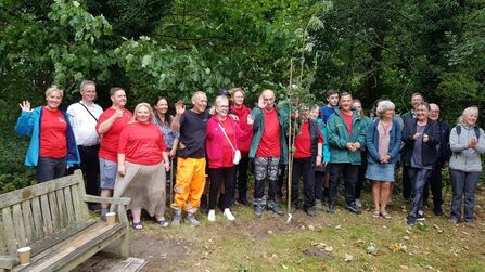A group of people waving and smiling at the camera 