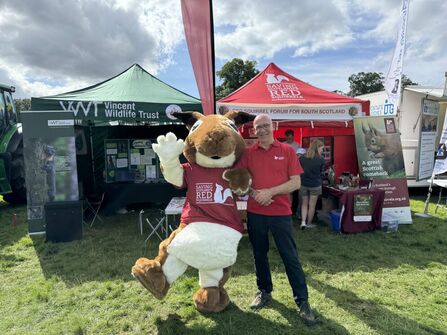 Tweeddale Volunteer stands with their red squirrel mascot at a local event