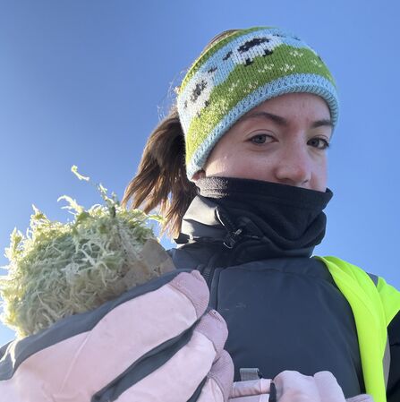 A girl wearing a headband holding some moss