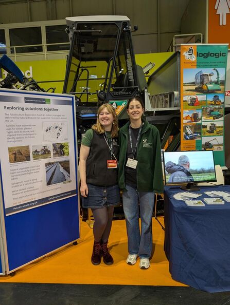 Two women stood in front of a tractor