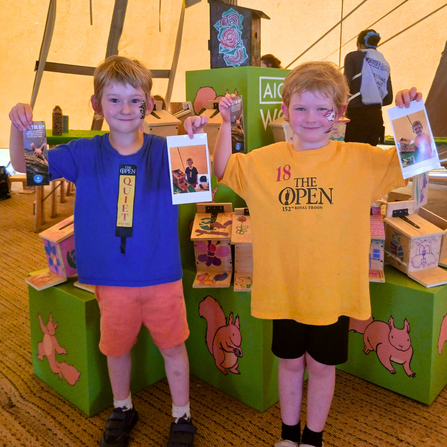 Young boys pose with specialised red squirrel feeders