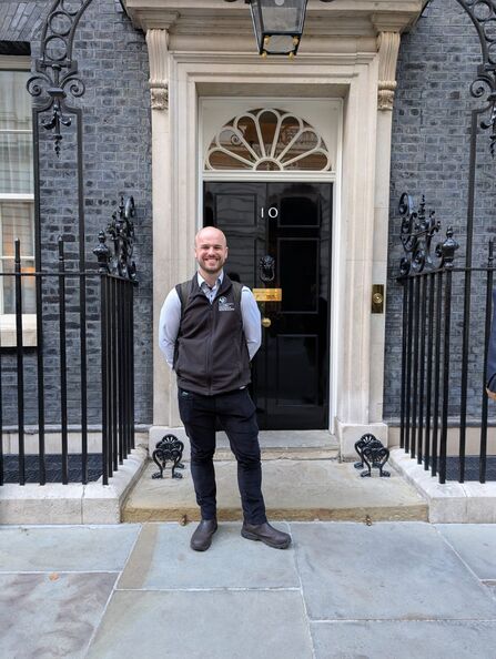 A man standing in front of the door to no 10