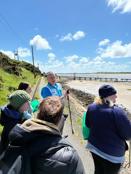 A group of people stood on the seafront