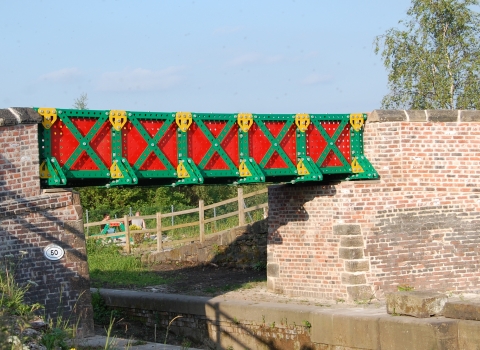 The bright red and green Meccano Bridge on the Kingfisher Trail