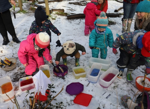 Children playing outdoors in the snow at Nature Tots