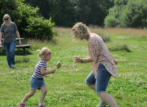 Mother and daughter playing on the grass during Nature Tots