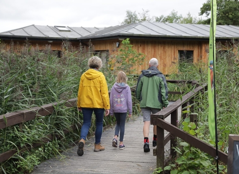 Family walks towards Mere Sands Wood Visitor Centre