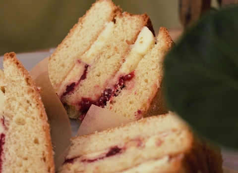 Three slices of Victoria sponge cake, filled with jam and buttercream, on a plate